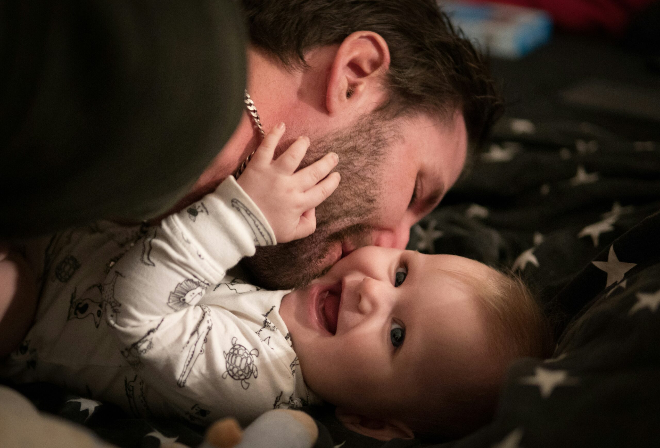 photo of a dad kissing his baby on the cheek