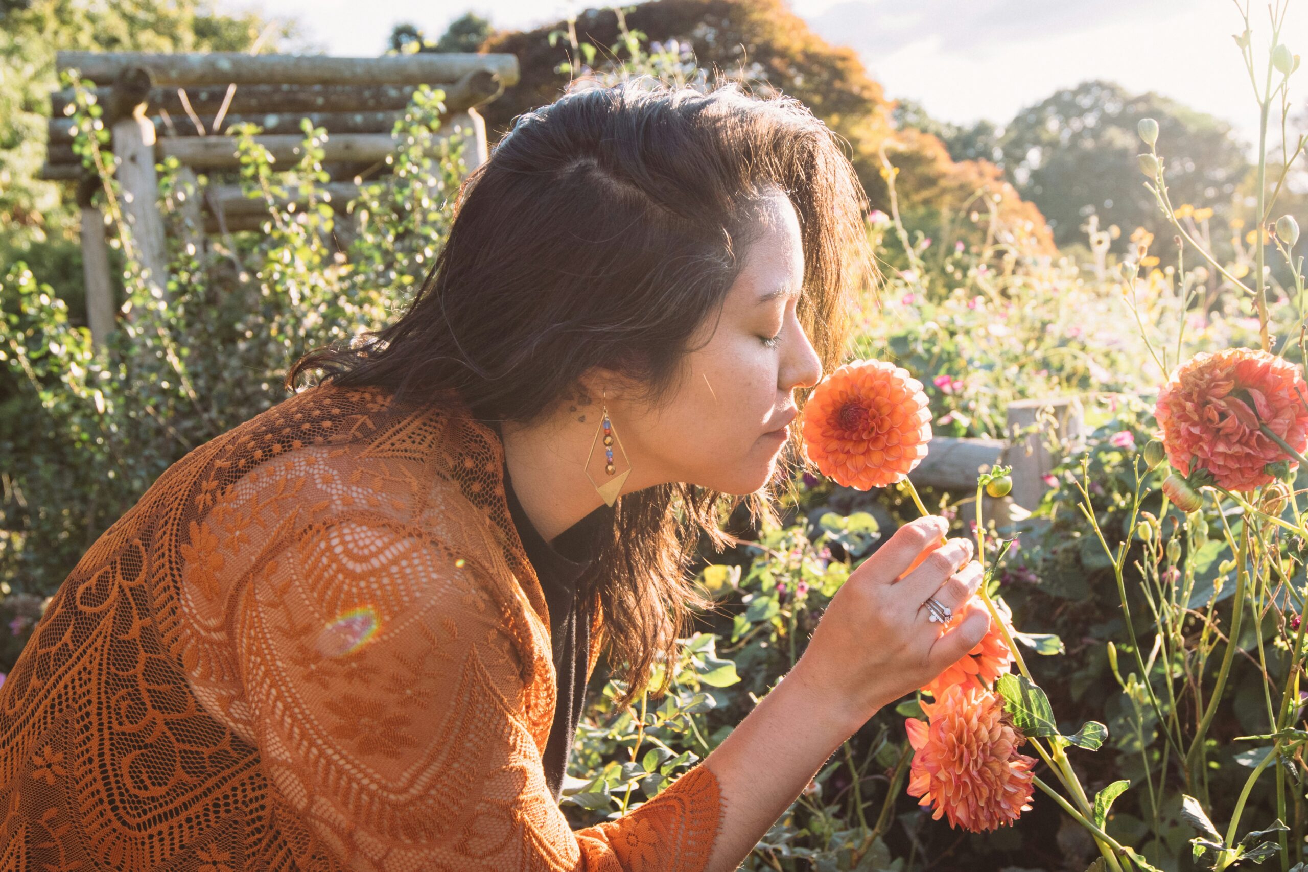 women smelling a dahlia flower
